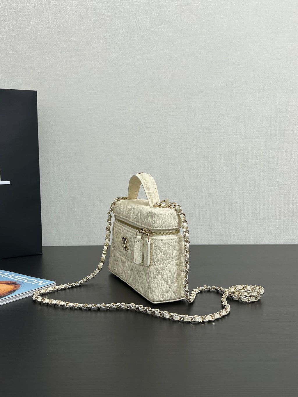 Chanel quilted leather mini bag, cream, side view with top handle and chain