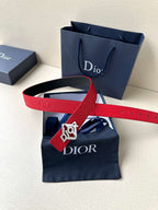 Red leather belt with silver buckle, flat lay showing embossed strap details.