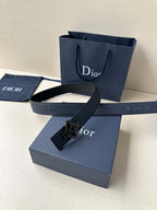 Dark blue leather Dior belt with square Dior logo buckle, laid over gift boxes.