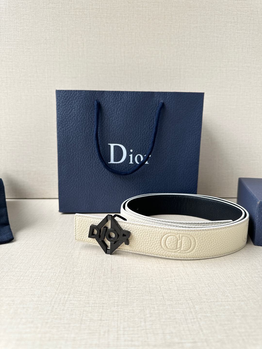 Ivory textured belt with dark Dior-logo buckle and black inner edge