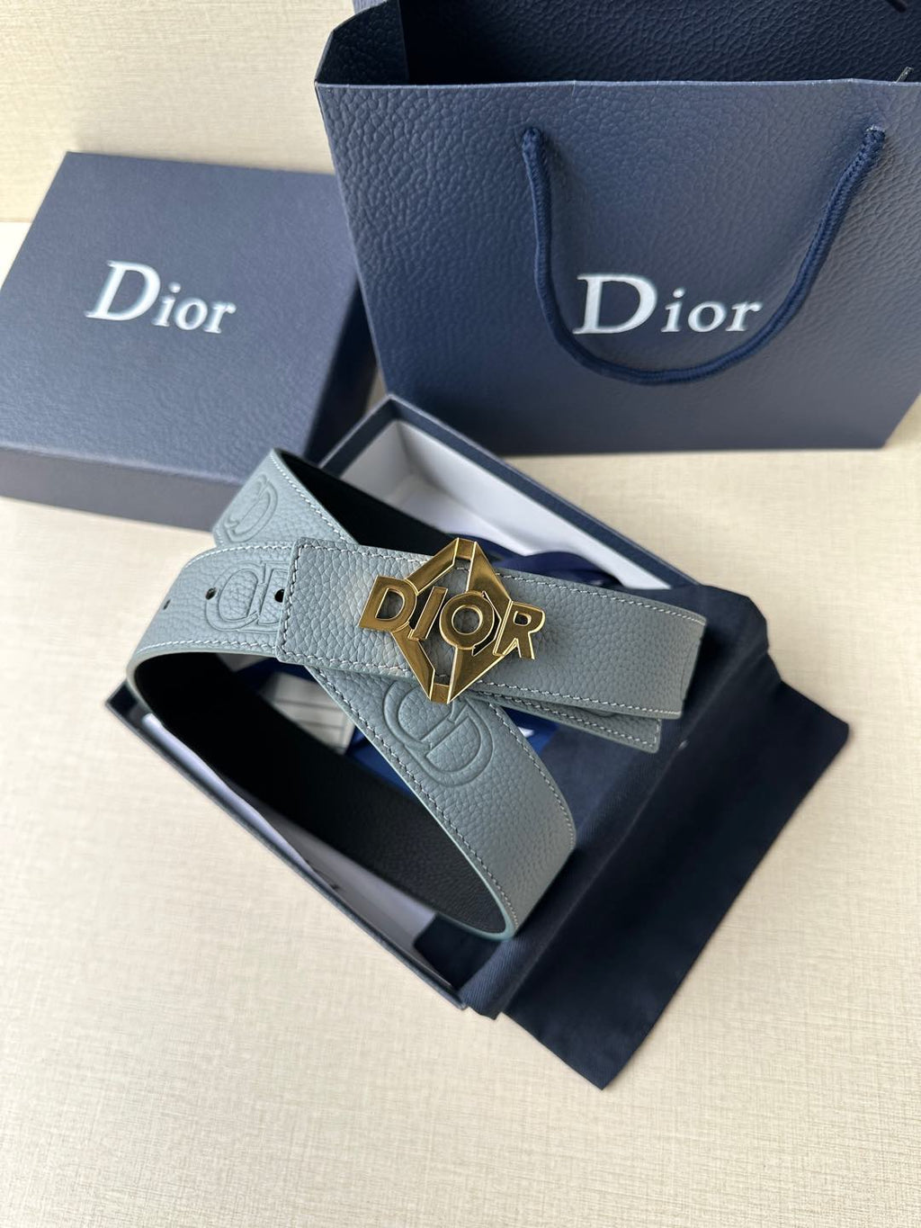 Dior belt in light blue leather with gold Dior buckle, styled in gift box
