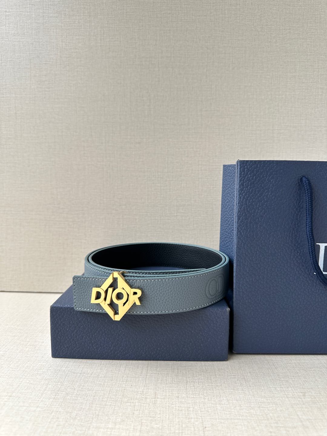 Dior belt in light blue leather with gold Dior buckle, shown with gift box