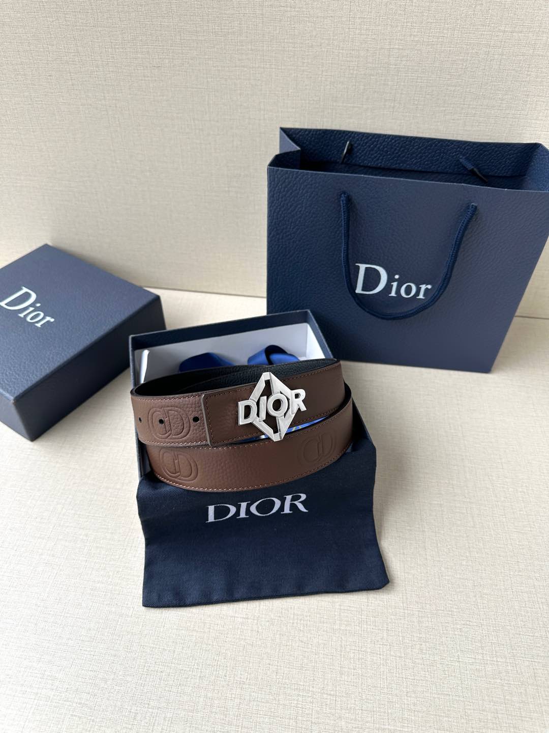 Dior belt with brown leather strap and gold-tone Dior logo buckle.