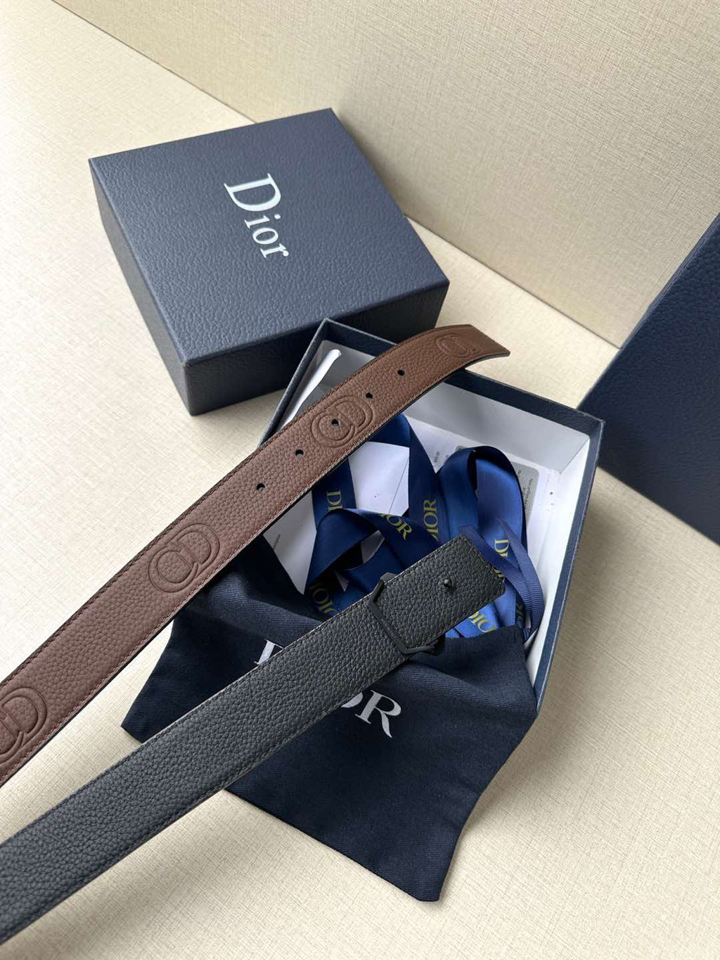 Dior belt in packaging: brown leather strap with gold-tone Dior logo buckle.