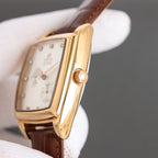 Gold-tone rectangular wristwatch with brown leather strap and crown detail