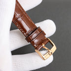 Brown leather watch strap with gold-tone buckle and stitched keeper