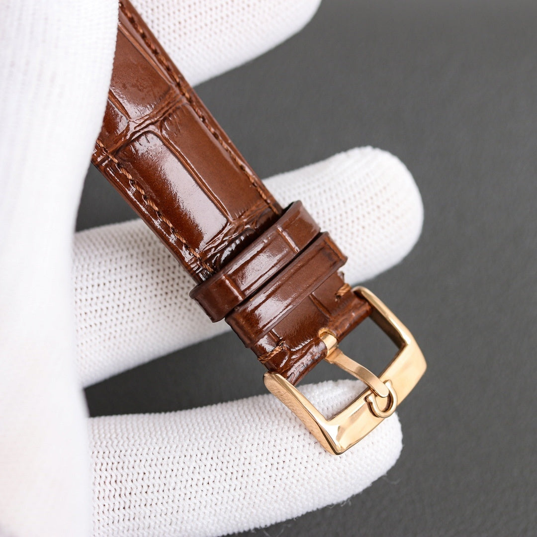 Brown leather watch strap with gold-tone buckle and stitched keeper