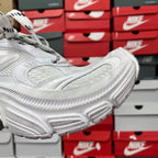 White sneaker side profile with thick cushioned sole and lace-up upper