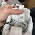 White sneaker interior tongue label with BALENCIAGA size chart and barcode