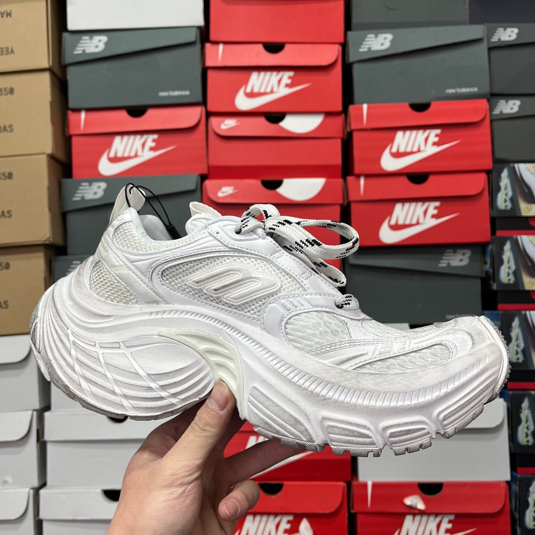 White lace-up athletic sneaker with chunky sole and embossed side detailing