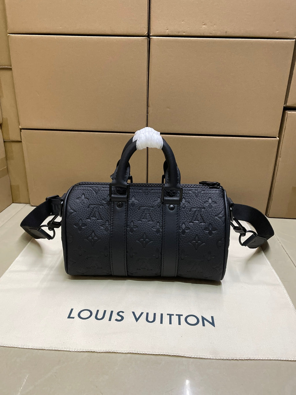 Monogram duffel bag with dual top handles and adjustable crossbody strap, dark leather