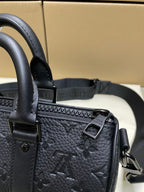Monogram leather bag close-up: top handle, tab hardware, and metal buckle, dark leather