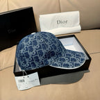 Dior logo-print denim cap in dark blue with curved brim and hanging tags.