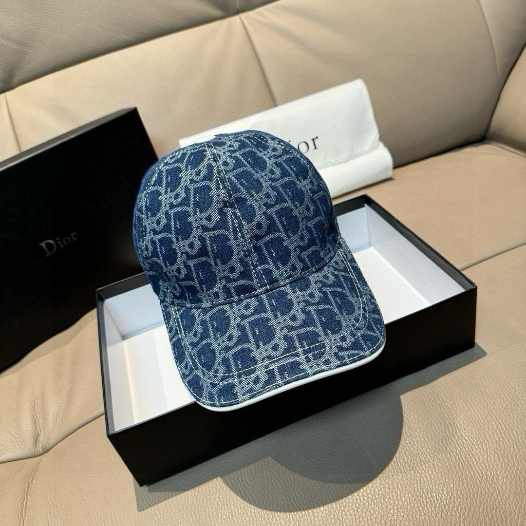 Dior logo-print denim cap in dark blue, shown from front-left on a gift box.