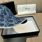 Dior logo-print denim cap brim close-up in dark blue with stitched edge.