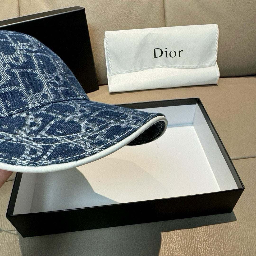 Dior logo-print denim cap brim close-up in dark blue with stitched edge.