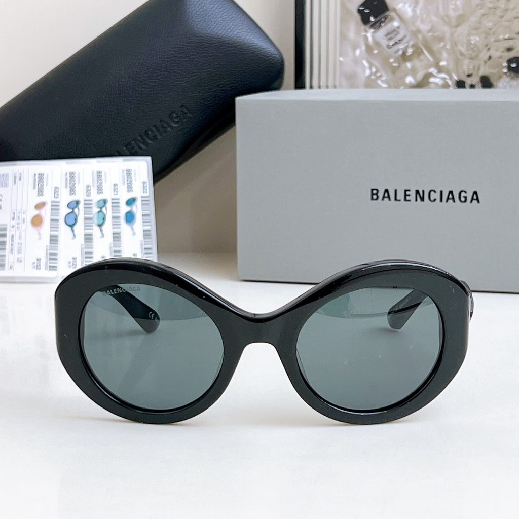 Balenciaga sunglasses with black oval frames and dark gray-tinted lenses