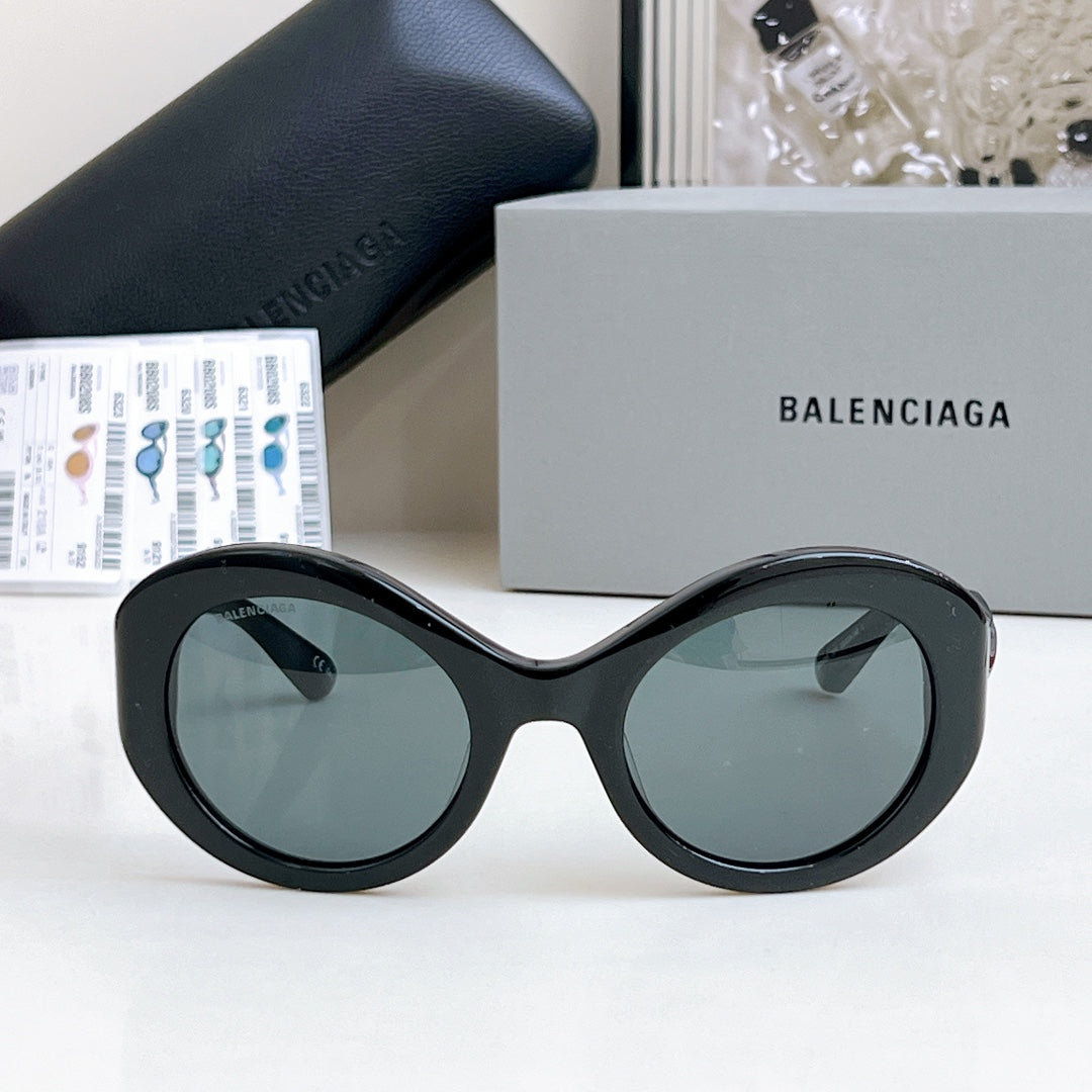 Balenciaga sunglasses with black oval frames and dark gray-tinted lenses