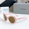 Balenciaga sunglasses with pink round frames and brown-tinted lenses