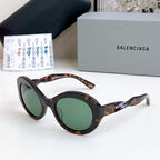 Balenciaga sunglasses with tortoiseshell frames and green-tinted lenses