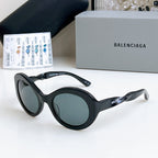 Balenciaga sunglasses with black round frames and gray-tinted lenses