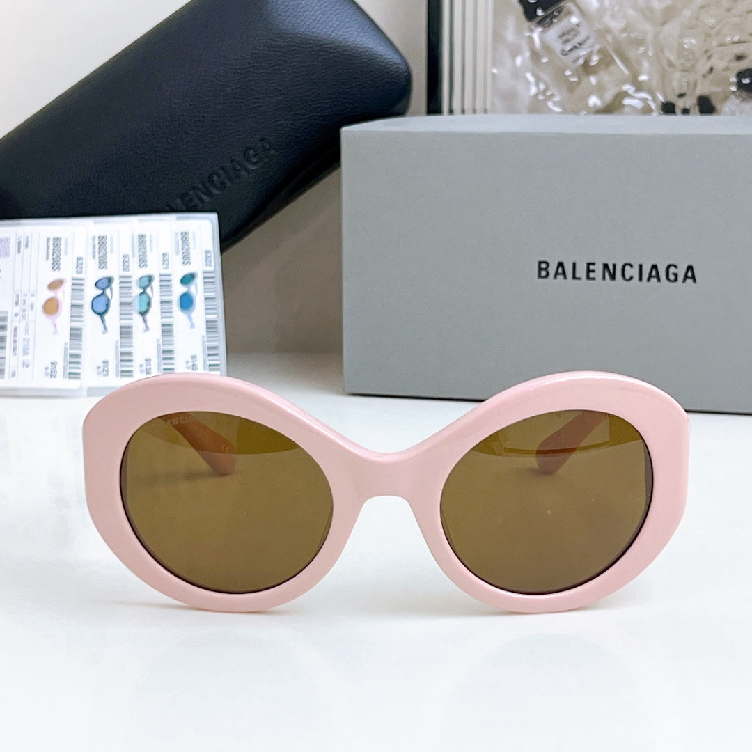 Balenciaga sunglasses with pink oval frames and amber-tinted lenses