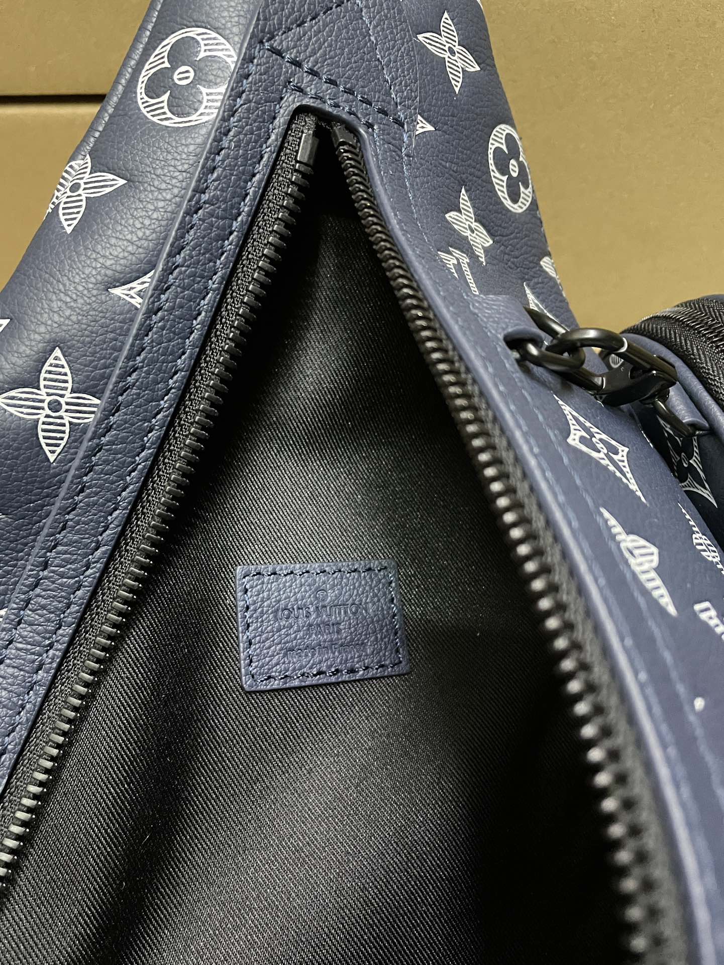 Men's navy monogram bag interior with black lining and open zip pocket