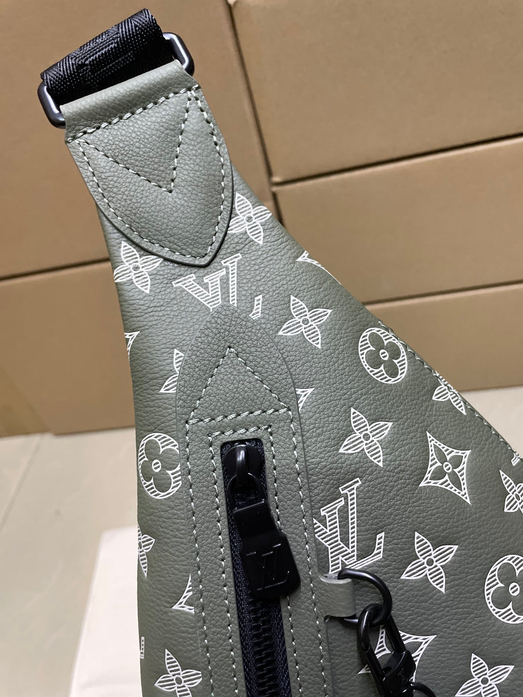 Louis Vuitton monogram sling bag detail, adjustable strap with metal buckle
