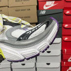 White and gray sneaker sole with black logo stripe, purple trim and lime accent.