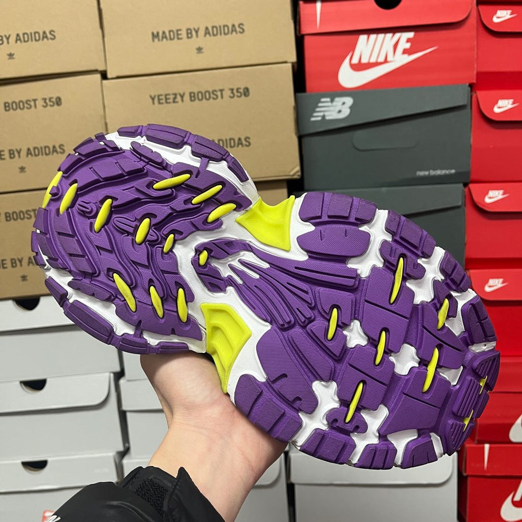 Purple and white sneaker outsole with zigzag traction and neon green pads.
