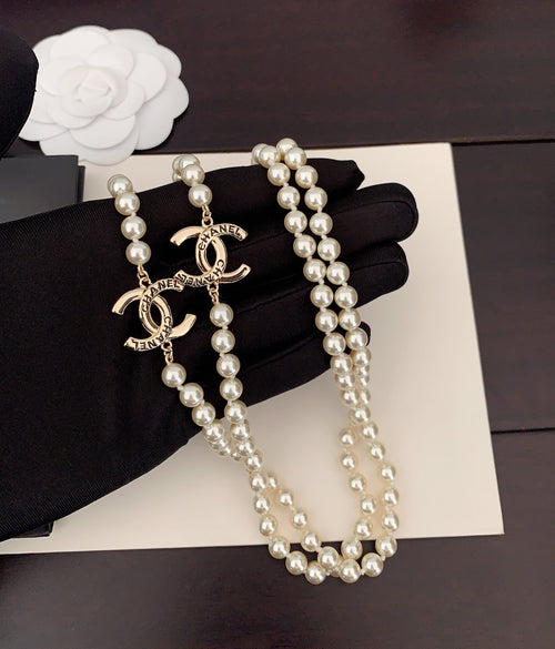Pearl necklace with gold Chanel logo charms and long dangling pearl strands