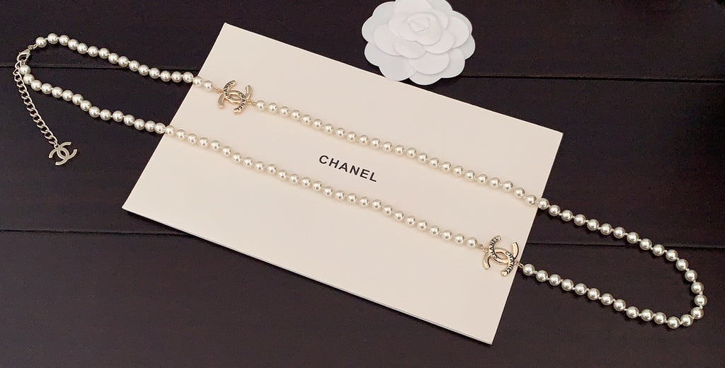 Pearl necklace with gold chain details on a branded card