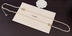 Pearl necklace with gold chain details on a branded card