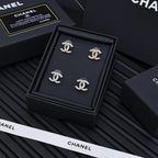 Set of four silver-tone Chanel CC stud earrings with rhinestone accents in box