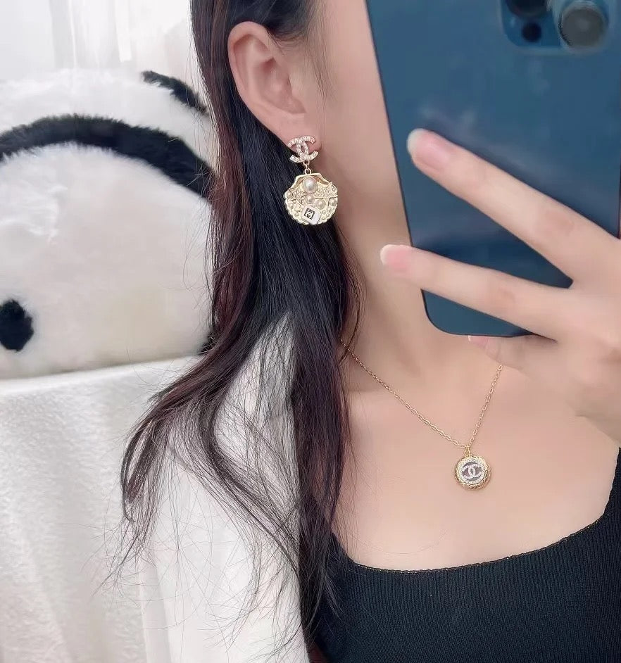 Gold-tone Chanel CC charm necklace with matching CC earring on model
