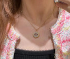 Gold-tone Chanel CC pendant necklace worn with black camisole
