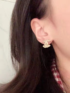 Silver-tone Chanel CC stud earring with rhinestone sparkle on ear