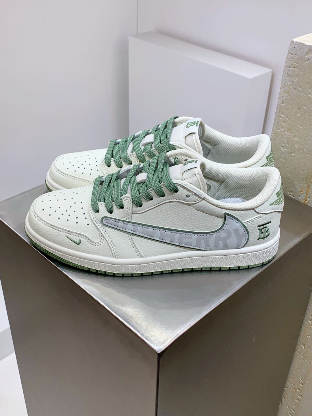 Burberry sneakers in white with green laces and perforated toe, front view pair