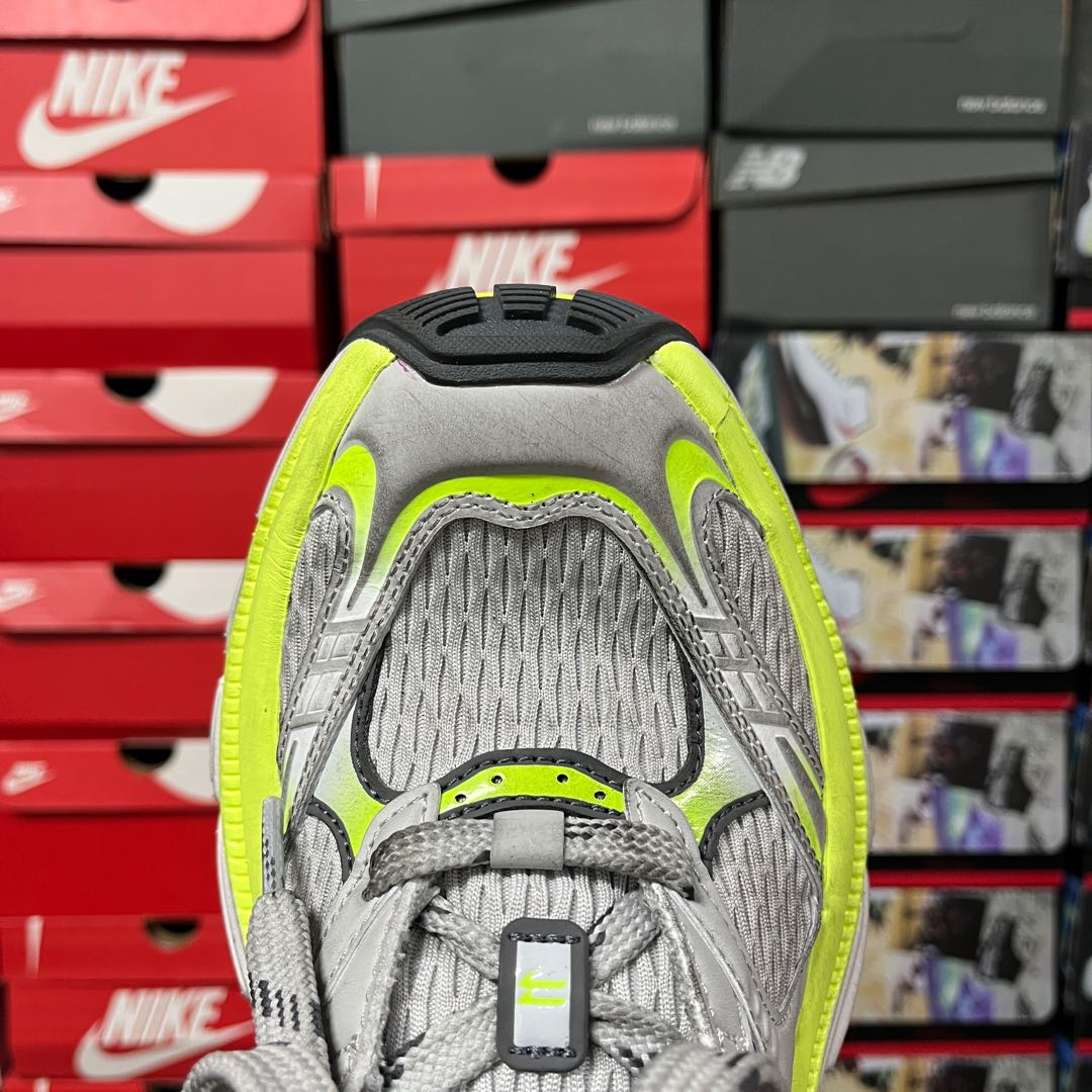 Grey mesh-backed sneaker with neon green collar and padded tongue tab