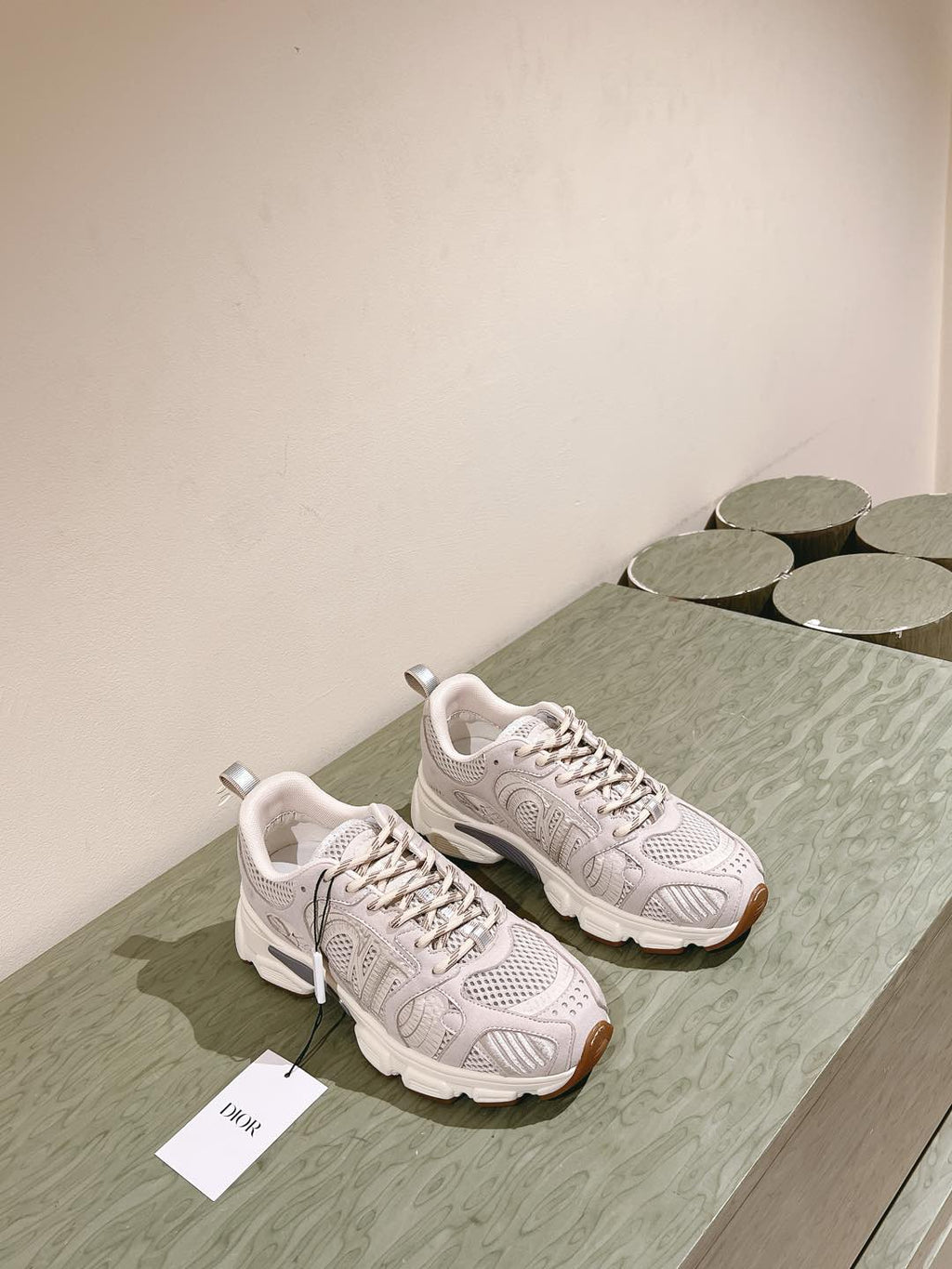 White Dior unisex sneakers on display with lace-up uppers and cushioned midsoles
