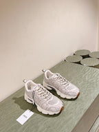 White Dior unisex sneakers on display with lace-up uppers and cushioned midsoles