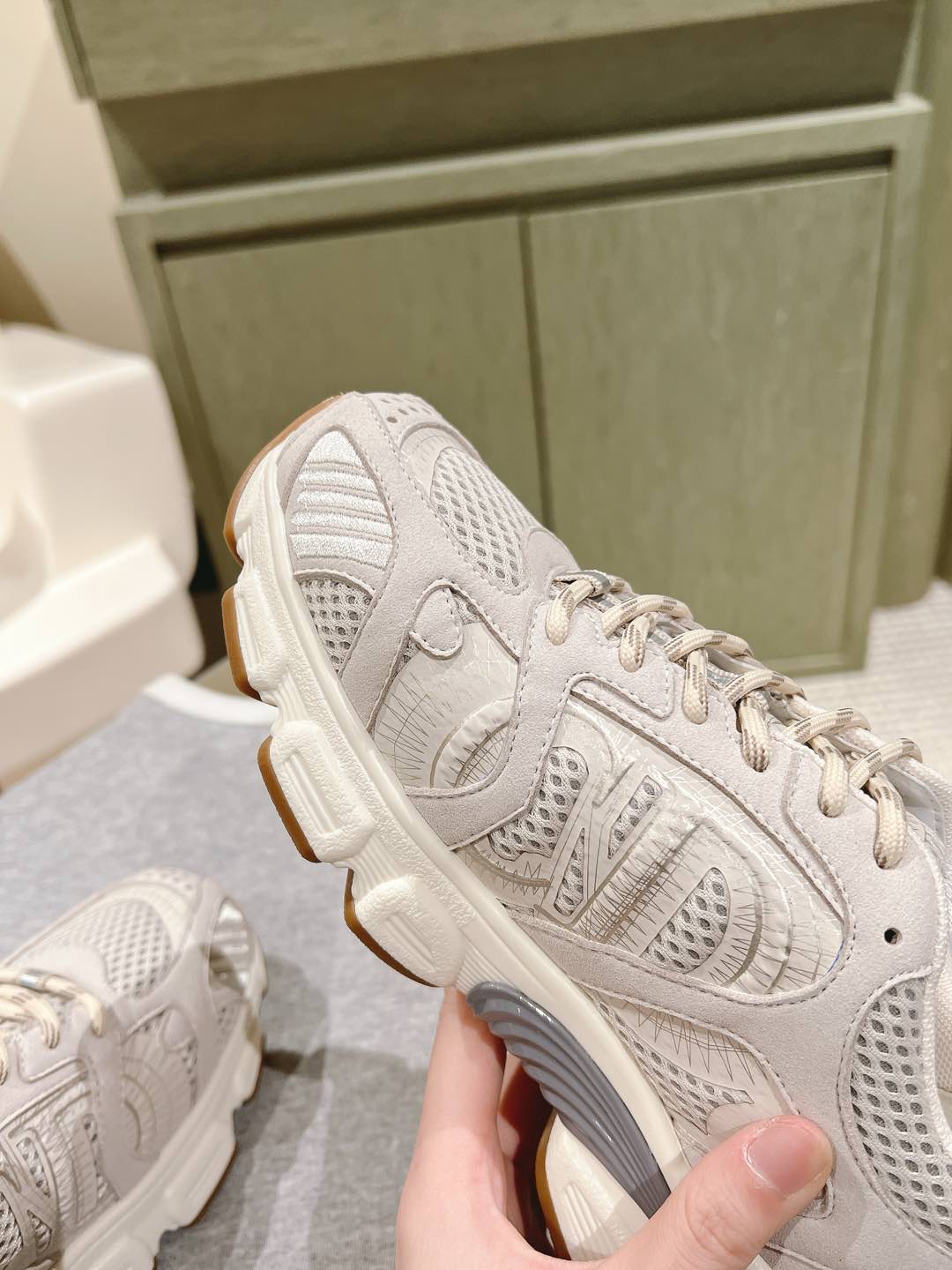 White Dior unisex sneaker close-up, side logo embossing and gum-style sole edge