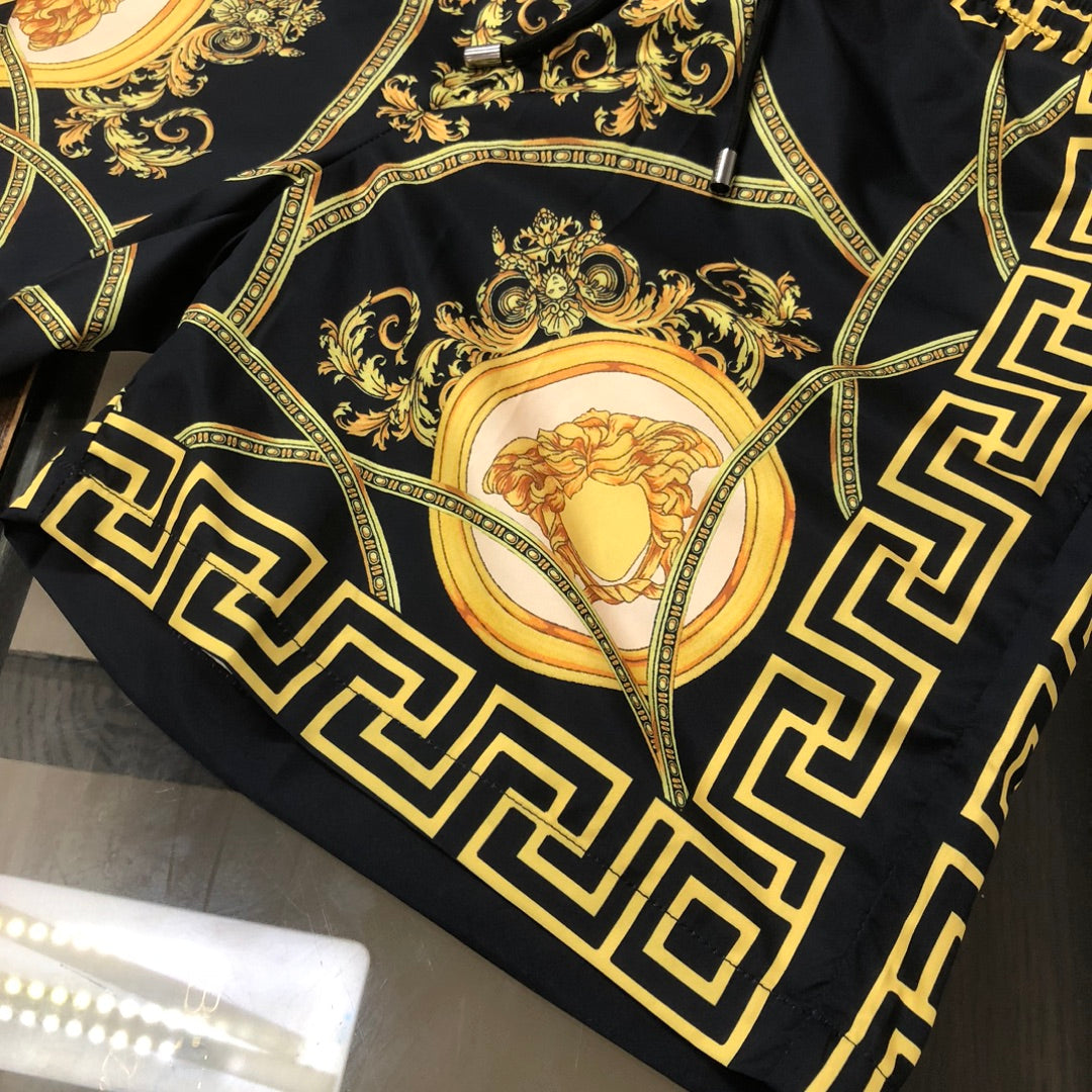 Versace swim shorts folded showing gold baroque scrollwork and oval medallion print