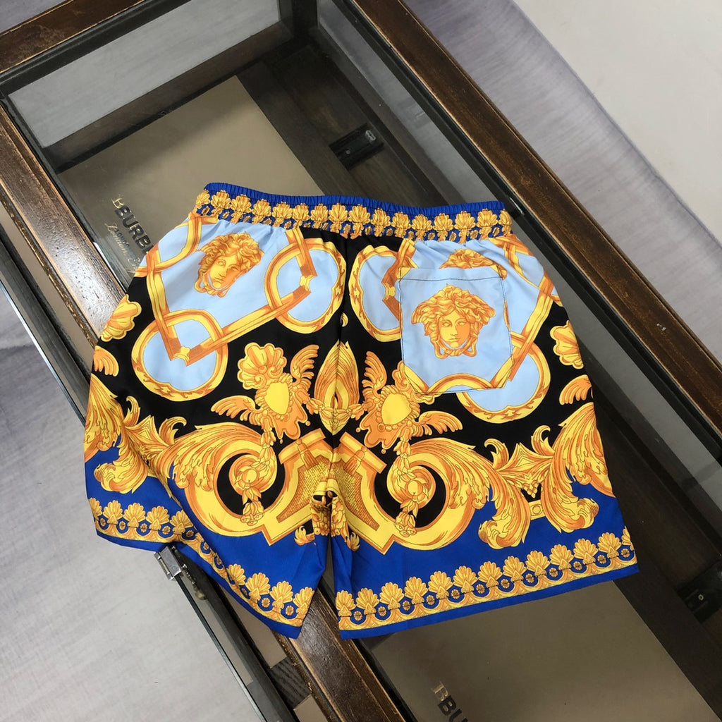 Versace shorts with black base, bright blue panels, and gold baroque emblem print