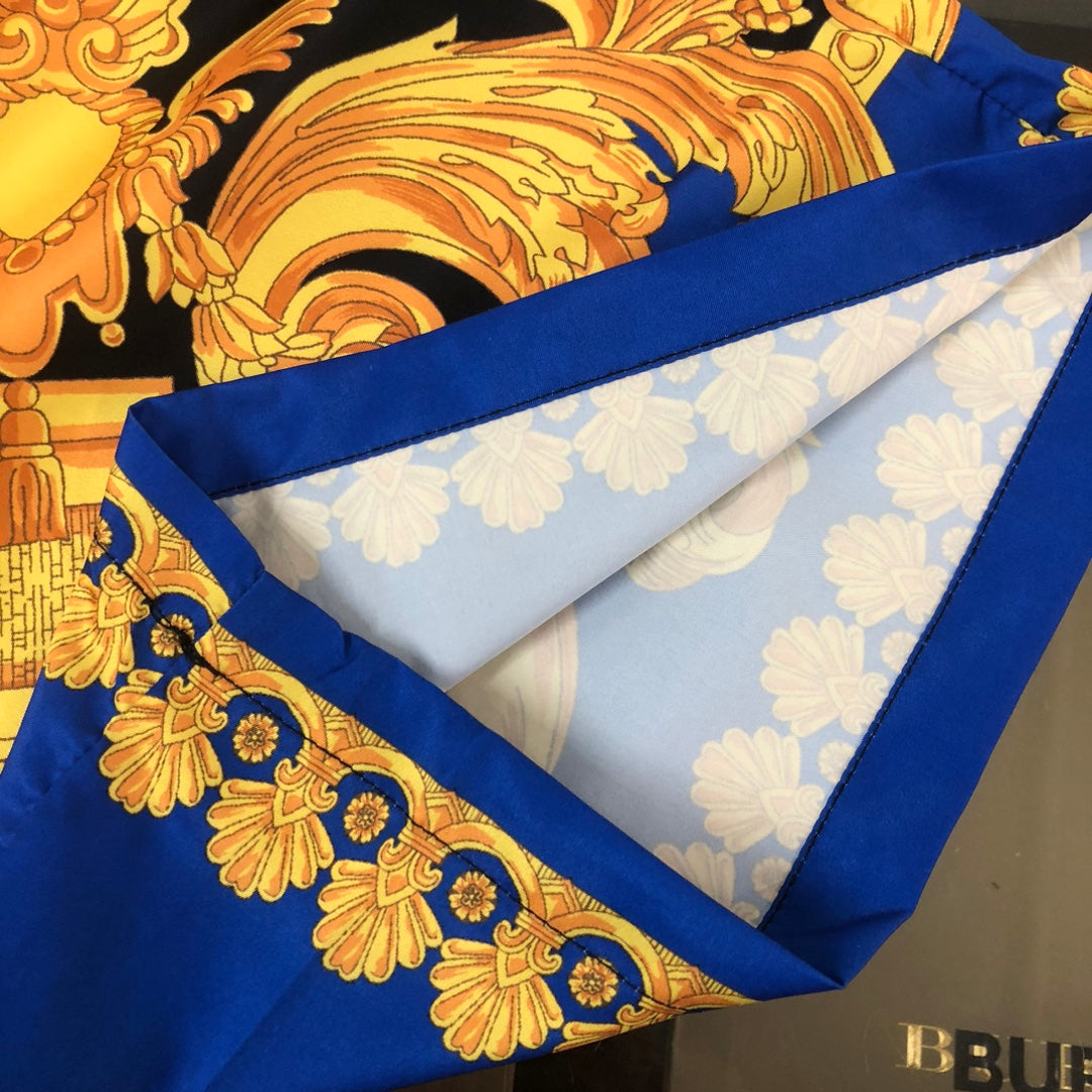 Versace shorts with blue trim edge and gold baroque print on black fabric