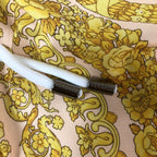 Versace waistband detail with white drawcord and gold floral baroque print