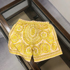 Versace patterned shorts with yellow drawstring and ornate gold baroque print
