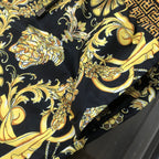 Close-up of black fabric with ornate gold baroque floral prints on the shorts.
