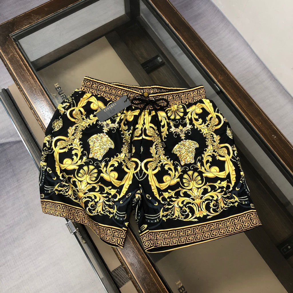 Black and gold baroque patterned shorts with Greek key border and drawstring waist.