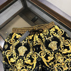 Black and gold baroque print shorts with Greek key trim along the waistband and cuffs.